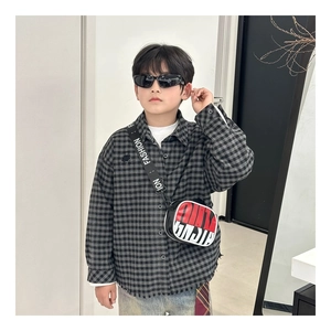 Detail of a kids crossbody bag with FASHION strap and trendy raw edge plaid shirt