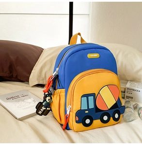 Close-up of blue and yellow excavator backpack with 3D cement mixer and cute dog charm
