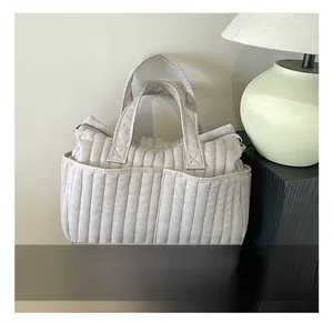 Detail der beige gesteppten Cord-Tragetasche mit Vordertaschen und Doppelgriffen