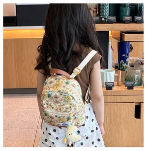 Detail of mini toddler backpack featuring embroidered bears and moon plush charm