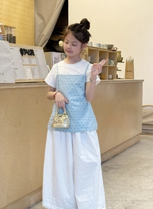 Mini sac à main à paillettes dorées avec haut bleu à pois et pantalon blanc