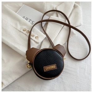 Close-up of litchi grain leather texture and gold hardware on kids mini bear bag