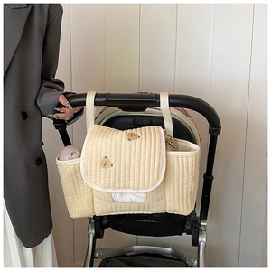 Détail de l'organisateur de poussette en coton matelassé crème avec broderie ours
