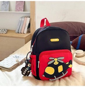 Detail of cartoon helicopter patch and zipper pocket on kids red and black backpack