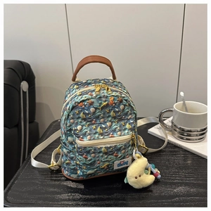 Detail of navy blue kids backpack with marine prints and yellow moon plush charm
