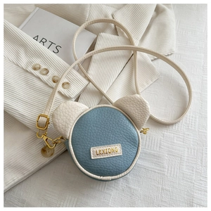 Detail of blue and beige bear ear crossbody bag with litchi texture and metal hardware