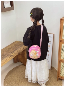Detailed view of pink crossbody bag with cartoon bear and adjustable strap for girls