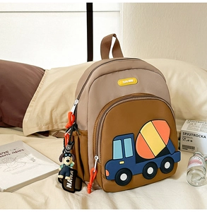 Detail of a large capacity kids backpack with a 3D cartoon cement mixer and a dog keychain