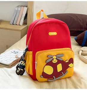 Detail of red and yellow kids helicopter backpack with cute dog plush toy pendant