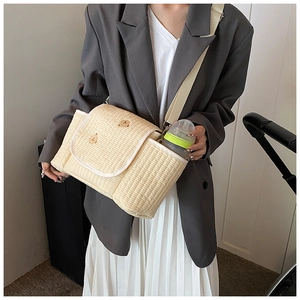 Détail du sac à langer matelassé beige avec broderie ours et poche latérale pour biberon