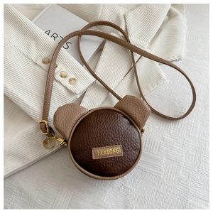 Detail of cute bear-shaped leather bag showing litchi texture and LKXIONG brand label