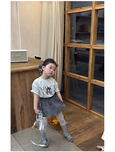 Detailed view of girls' grey fashion outfit set with skirt, silver bag and matching shoes