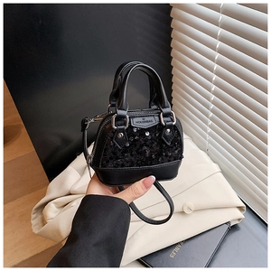 Détail d'un mini sac à bandoulière à paillettes noires avec plaque logo et zip métallique