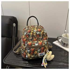 Detail of mini printed backpack with cartoon animal patterns and yellow moon plush charm