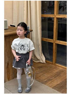 Flat lay of girl's gray outfit with silver handbag and puppy charm accessory