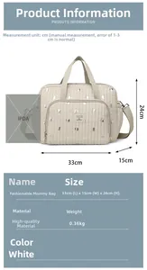 Detail view of cream quilted diaper bag with silver dots and functional zipper pockets