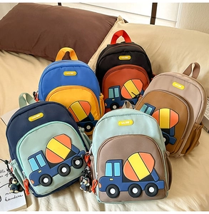 Close-up of children backpack series with 3D construction truck designs and doll pendants