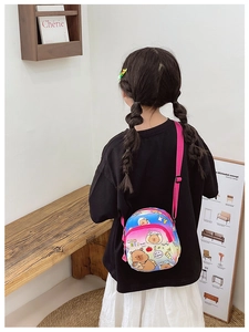 Rear view of a child wearing the colorful cartoon bear crossbody bag with pink strap