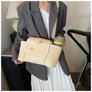 Détail du sac à langer matelassé beige avec broderie ours et poche latérale pour biberon