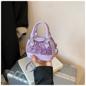 Détail du mini sac coquille à paillettes violettes avec logo embossé et anneaux