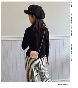 Vue détaillée du sac bandoulière rose en forme de cœur avec chaîne dorée pour enfant