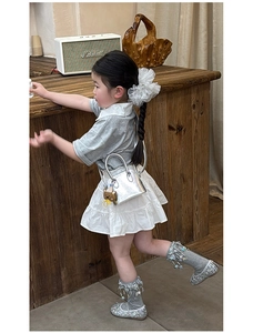Silver metallic handbag with brown teddy bear charm paired with girls grey polo shirt outfit