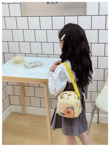 Close-up of kids crossbody bag featuring a cartoon Capybara print on bright yellow fabric