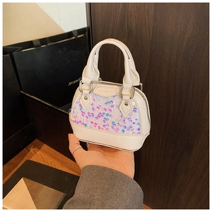 Gros plan du mini sac à main à paillettes irisées avec étiquette gaufrée HOUJINBAG pour enfant