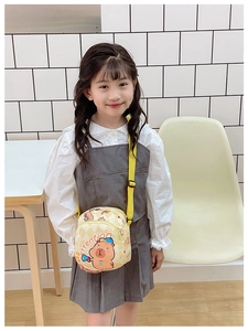 Close-up of girl wearing a yellow cartoon capybara shoulder bag with adjustable strap