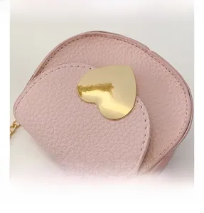 Détail du sac bandoulière rose pour enfants avec une grande boucle en métal doré en cœur