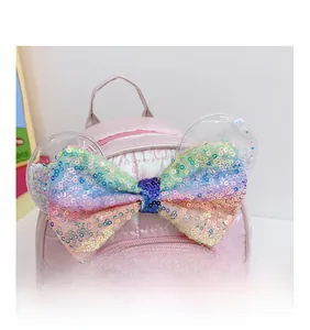 Dettaglio dello zaino rosa per bambini con fiocco di paillettes e orecchie lucide