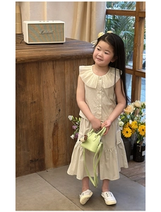 Detailed view of kids sleeveless ruffles top and tiered skirt in cream cotton fabric