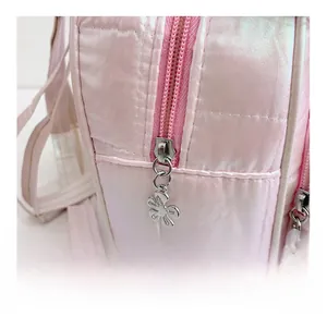 Dettaglio dello zaino rosa con paillettes che mostra zip fluida e tiralampo a fiore