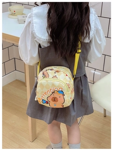 Detailed back view of a yellow checkered Capybara crossbody bag worn by a child
