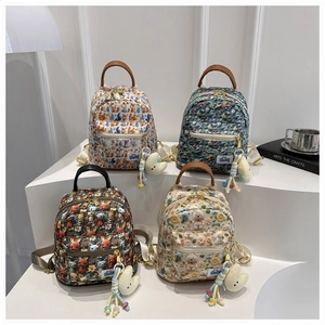 Set of four mini kids backpacks with cartoon animal prints and plush moon pendants