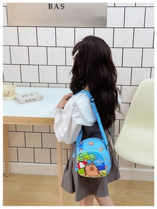 Blue kids capybara crossbody bag with adjustable strap shown on a young child model