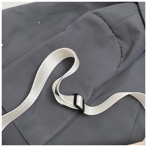 Detail of adjustable white nylon strap and black plastic buckle on kids' crossbody bag