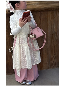 Detail of pink toddler handbag with lychee leather texture and cute puppy charm