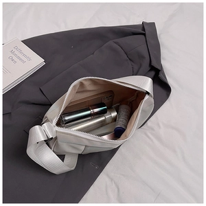 Close-up of a white striped crossbody bag showing internal capacity for daily items