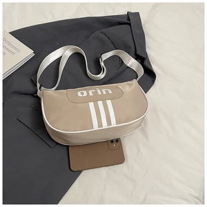 Detail showing beige nylon shoulder bag capacity with a smartphone inside for size contrast