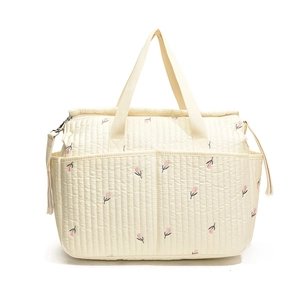 Quilted cotton diaper bag with cute floral embroidery and adjustable shoulder strap