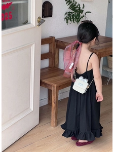 Girl wearing black summer dress with white chain straw bag and silver bow detail