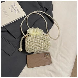 Detailed view of mini pearl woven bag showing size comparison with a smartphone