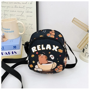 Detail shot of a black capybara crossbody bag with RELAX text on a lifestyle background