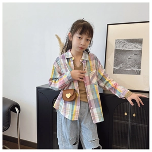 Détail d'une chemise à carreaux enfant avec boutons en cœur et jean délavé
