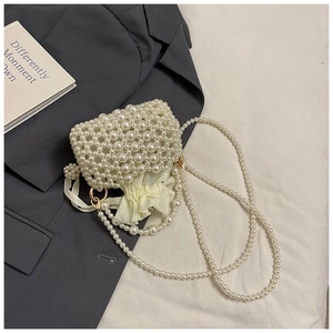 Detail of woven pearl beads on a mini crossbody bag with ruffled drawstring lining