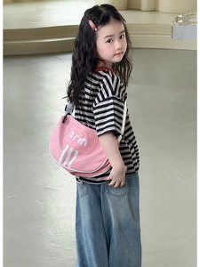 Close-up of pink canvas shoulder bag for kids with white stripe and letter printing
