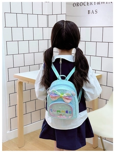 Dettaglio dello zaino verde menta per bambini con fiocco di paillettes e tasca PVC