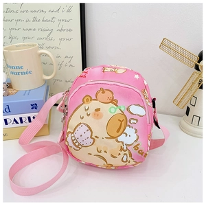 Detailed close-up of a pink cartoon capybara crossbody bag with adjustable strap on a desk