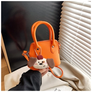 Detailed macro view of orange litchi grain leather texture and plush puppy charm